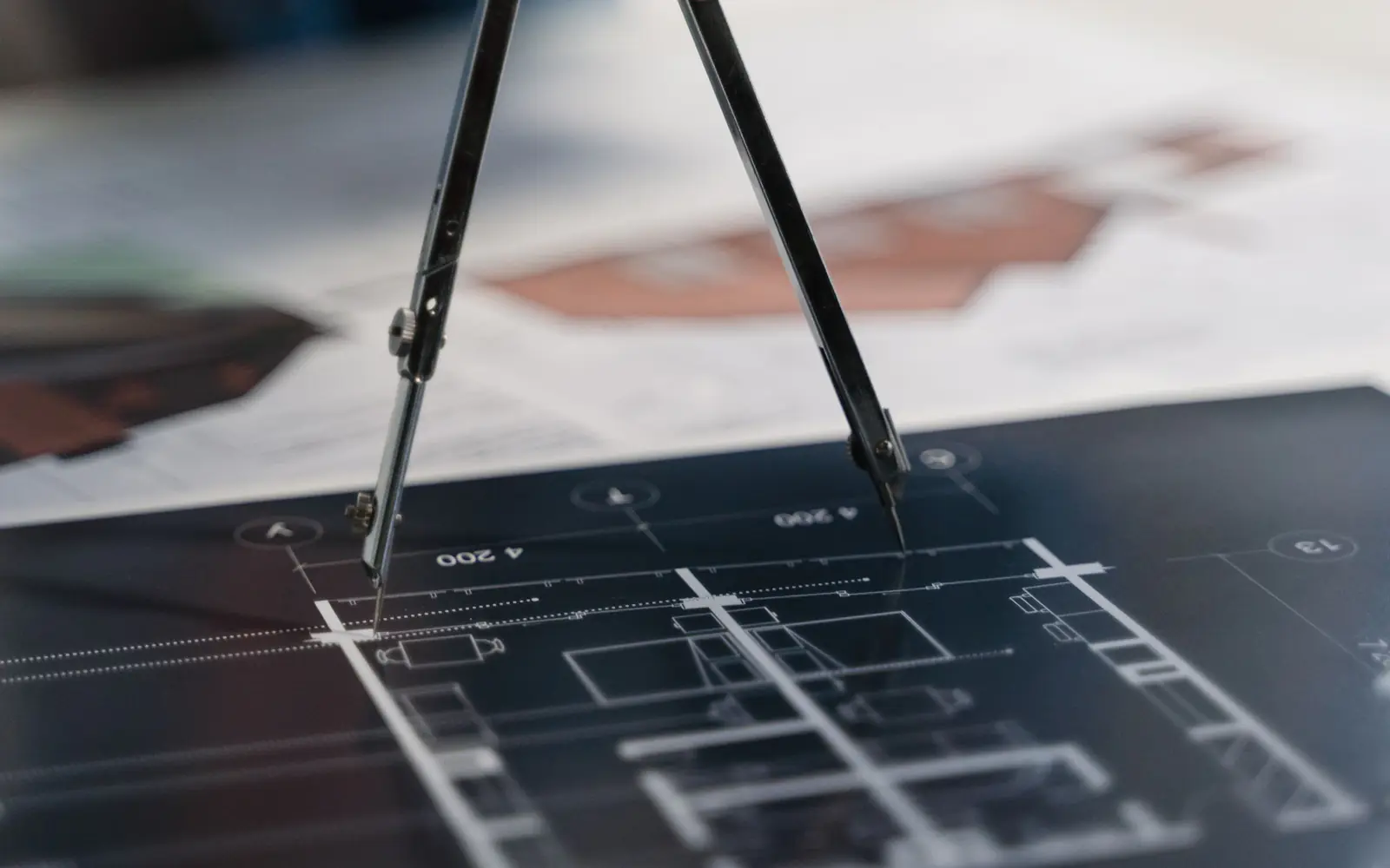 A pair of dividers resting on an architectural drawing