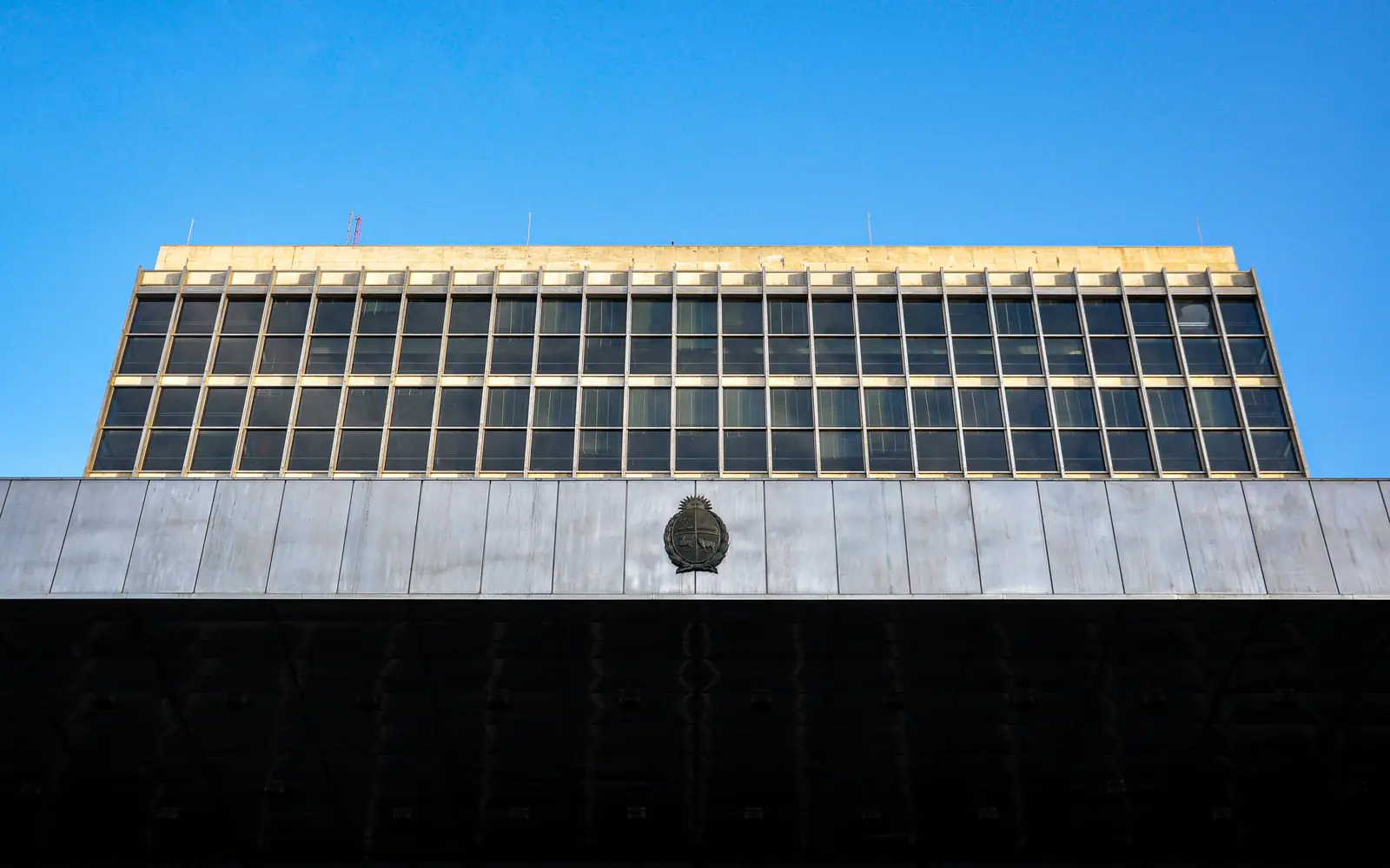 The facade of a modernist government office building against a clear sky