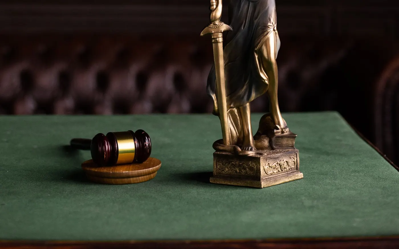 A figure of Justice and a gavel in a law library